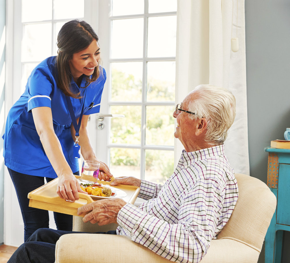 a caregiver woman serving an elderly man