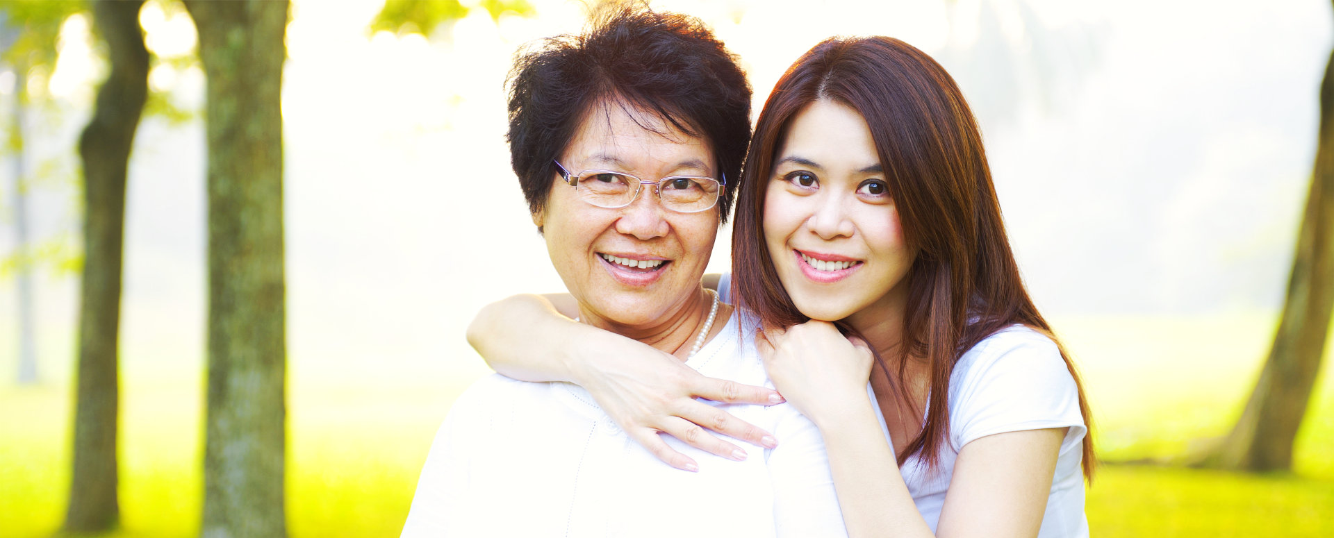 an adult woman hugging an elderly woman