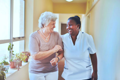 caregiver and old woman walking int the lobby